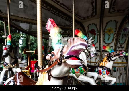 Detail of a nostalgic carousel with artfully painted horse figures and colorful feathers, Georgia, Kutaisi, old amusement park Stock Photo