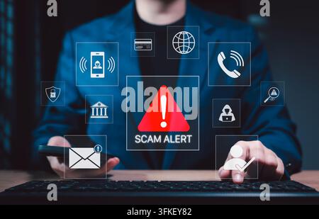 Scam alert warning. Cybersecurity concept. Woman using computer and smartphone, warning sign for scams representing online threats, phishing, cybersec Stock Photo