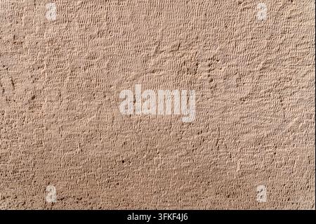 Textured stucco wall displaying rough plaster finish on facade. Stock Photo