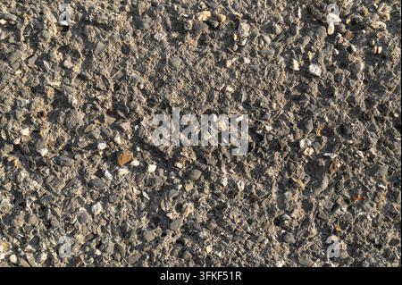Rough aggregate concrete showing exposed stone texture on pavement. Stock Photo