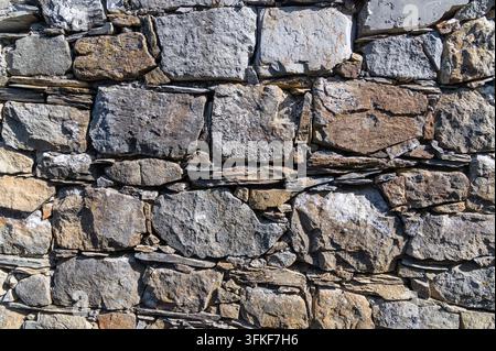Stone wall with fitted rectangular blocks in outdoor facade. Stock Photo