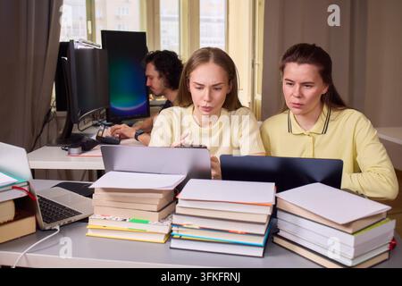 Colleagues work on design. Professionals analyze data and brainstorm in office environment. Team engaged in detailed discussion and analysis of Stock Photo