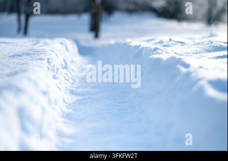 Snow-covered path with soft blurred background. Minimal winter scene, cold season texture, clean background with copy space Stock Photo