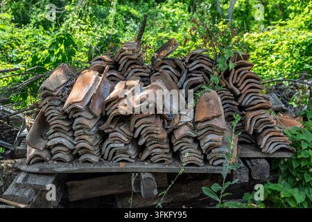 Weathered terracotta roof tiles are neatly stacked on wooden pallets, Rajac,  Rajačke Pimnice/Pivnice, Serbia Stock Photo