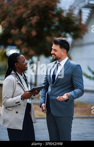Diverse business professionals having informal meeting outdoors Stock Photo
