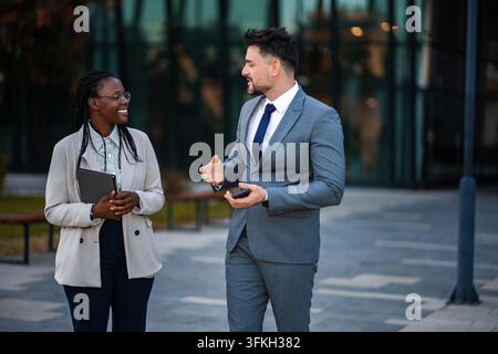 Diverse business professionals having informal conversation outdoors Stock Photo