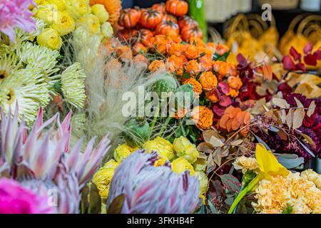 Colorful flower arrangement with diverse blooms, including roses, chrysanthemums, and ornamental flowers, densely packed in a visually appealing manne Stock Photo