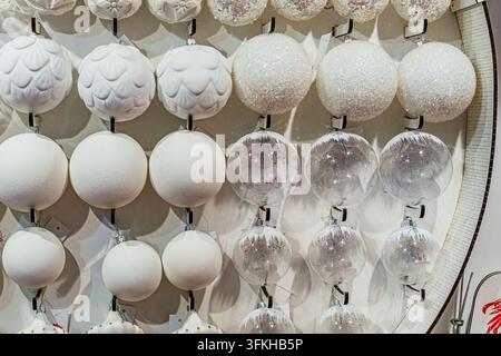 Festive spherical ornaments display in grid pattern on wall, featuring varied designs and textures, bright even lighting, smooth white background, ele Stock Photo