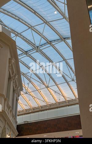 A grand, beige-walled room with a domed ceiling featuring small white lights Natural light filters through a draped window, creating a warm and inviti Stock Photo