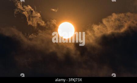 Dazzling sun shining through clouds Stock Photo