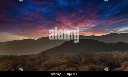 Sunset and fire clouds over Yu Feng Pagoda on Yuquan Hill in Beijing, with mountain silhouettes Stock Photo