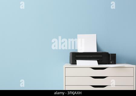 Remote work and home office productivity, modern printer on a white drawer unit with blank paper for document printing and administrative tasks Stock Photo