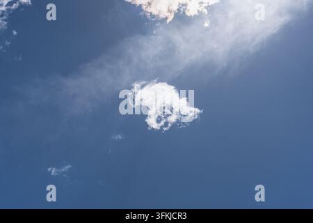 Single fluffy isolated white cloud in the center of clear blue sky Stock Photo