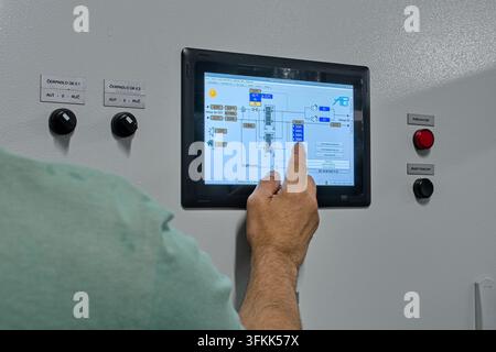 Operator hand touching touchscreen control panel of industrial automation system in a boiler room in Bratislava, September 24, 2026. Stock Photo