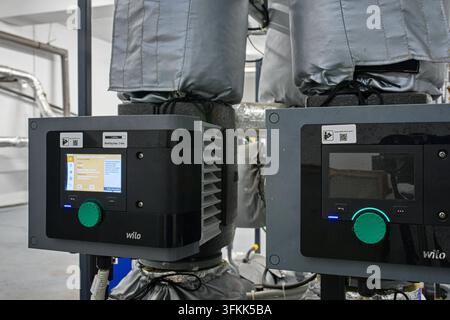 Close-up of electronic control panels of modern industrial Wilo circulation pumps featuring digital displays in a boiler room. Stock Photo