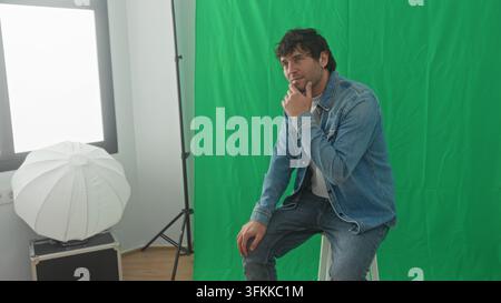 Woman photographer holds camera and shows image to seated man model with hand on shoulder in studio; friendly collaboration. Stock Photo