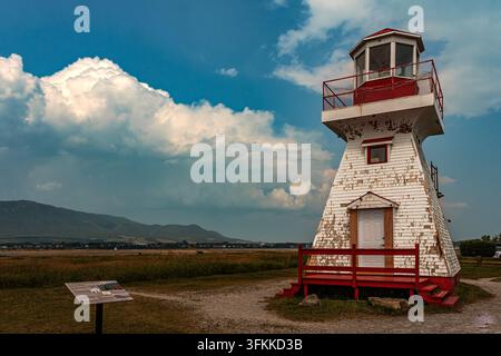Weathered white and red Tracadigash Point Lighthouse with cumulus clouds over the bay. Carleton-sur-Mer, Gaspesie, Quebec, Canada, North America Stock Photo