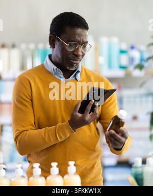 Adult man buyer scanning qr code for medicinal syrup in pharmacy Stock Photo
