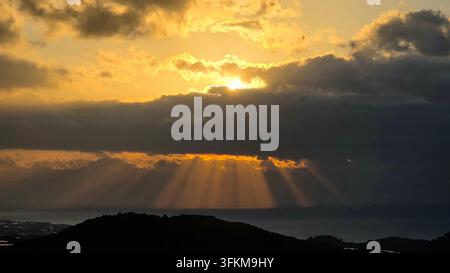 Sunbeams breaking through dramatic clouds over the sea Stock Photo