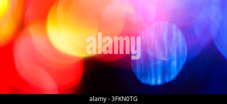 Abstract blurred bokeh background with soft red and yellow circles crossed by blue streaks Stock Photo