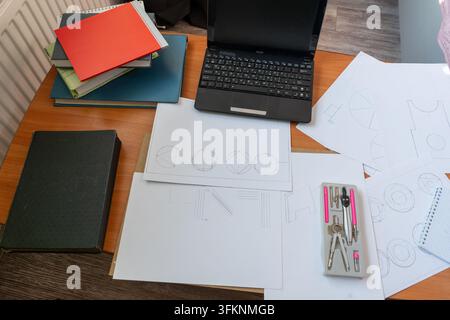 Workspace laptop technical drawings compasses supplies, top view of architect geometric sketches. Drawing training. Homework on the table. Sheets of paper notebook Stock Photo