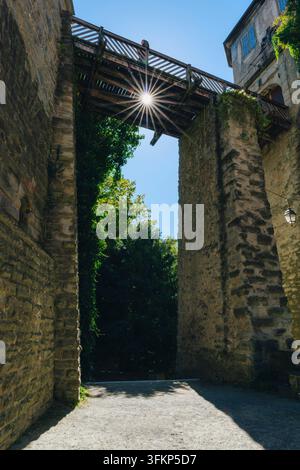 Architectural photo of the wooden access bridge to the Old Meersburg Castle, supported on high natural stone walls under a blue sky with sun stars, Me Stock Photo