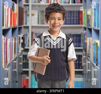 Smiling schoolboy standing in a library Stock Photo