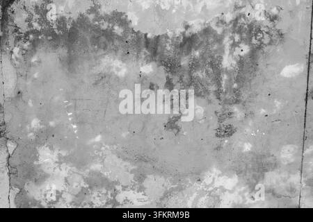 A horizontal black and white texture background featuring a flat concrete or plaster surface heavily weathered over time. The composition shows dark m Stock Photo