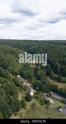 Aerial view of Schloss Mespelbrunn surrounded by dense green forest and ...
