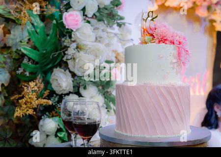 Elegant two-tier wedding cake with pink and white frosting and flower decorations Stock Photo