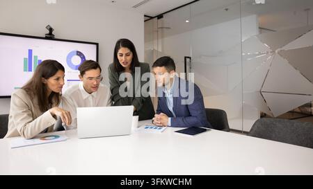 Corporate staff collaborating on digital project using laptop at boardroom Stock Photo