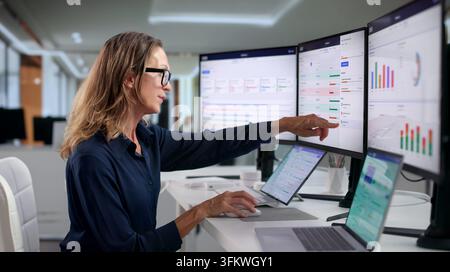 Project Manager Reviews Team’s OKR Progress Using Laptop For Detailed Analysis. Stock Photo