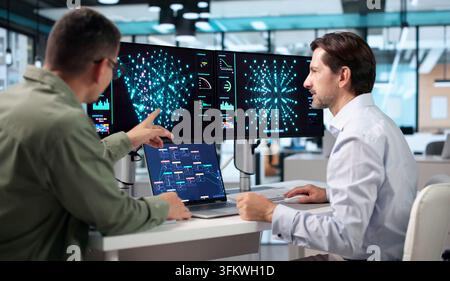 Data Scientist And Engineer Collaborate On Laptop Using AI Tools Together. Stock Photo