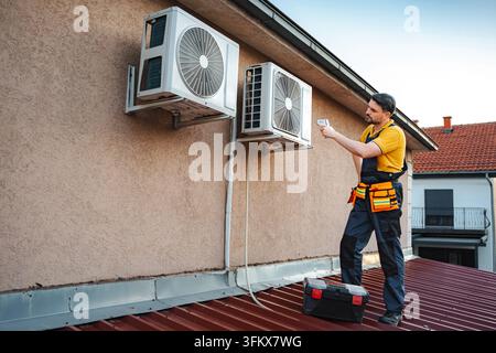 Hvac technician checking outdoor air conditioning unit temperature Stock Photo