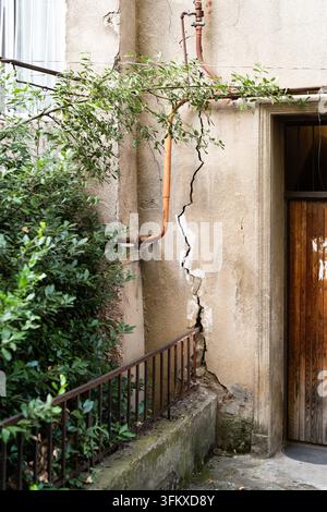 Crack in building caused by ground movement provoked by works at construction site or earthquake. Stock Photo