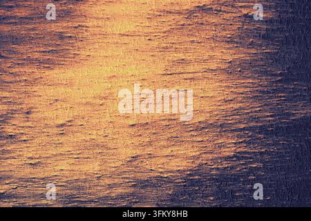 Abstract dark purple and glowing golden rough texture background. Stock Photo
