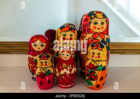 A vibrant collection of traditional Russian nesting dolls, or matryoshka, displayed neatly on a white surface, showcasing intricate hand-painted flora Stock Photo