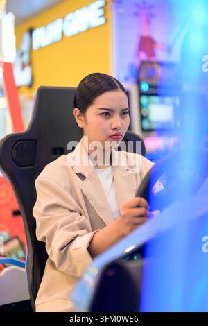 A professional front-angle portrait of an intense young Southeast Asian Thai businesswoman from the Isan region looking forward with concentration whi Stock Photo