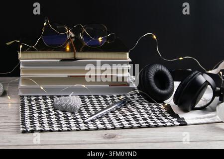 Stack of books and notepads with glasses and on the side of headphones. beautiful background. View of the top Stock Photo