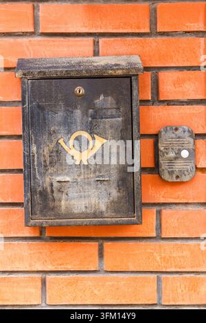 Old black mailbox on the wall of red brick Stock Photo
