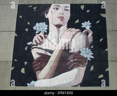 Woman portrait with light and dark skin hands embracing her, holding white lotus flowers Stock Photo