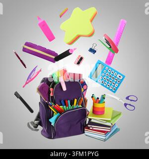 Stationery flying over backpack against grey gradient background Stock Photo