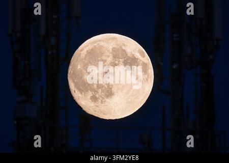 The full moon, which is also called harvest moon or autumn moon in September, glows in the evening sky, Frankfurt am Main, Hesse, Germany Stock Photo
