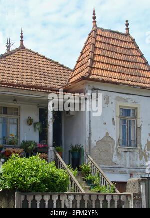 House facade with peeling paint, a charming entrance, and a unique terracotta roof Stock Photo