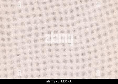 Beige woven linen fabric displaying a subtle texture, creating a neutral and natural textile background perfect for design elements, backdrops, and ma Stock Photo
