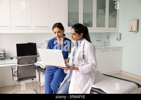 Two female medical professionals working together using laptop Stock Photo