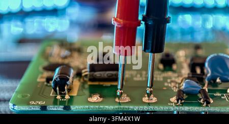 Electronic Circuit Board Testing with Multimeter Probes for PCB Diagnostics, Voltage Measurement and Hardware Repair Stock Photo