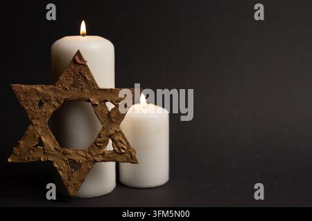 Star of David with two memorial candles on black background Stock Photo