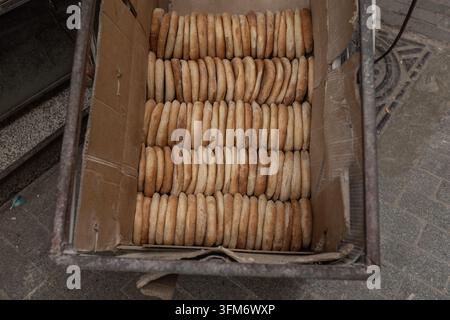 A large stack of traditional Moroccan semolina biscuits (fekkas) displayed in neat rows on a market stall in the medina of Fez, Morocco Stock Photo