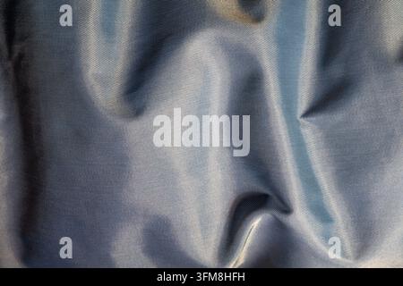 Detailed close up woven fabric texture showing folds and light reflection Stock Photo